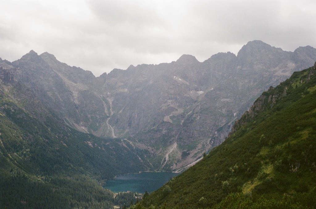 Emerald colored mountain lake surrounded by green hills.