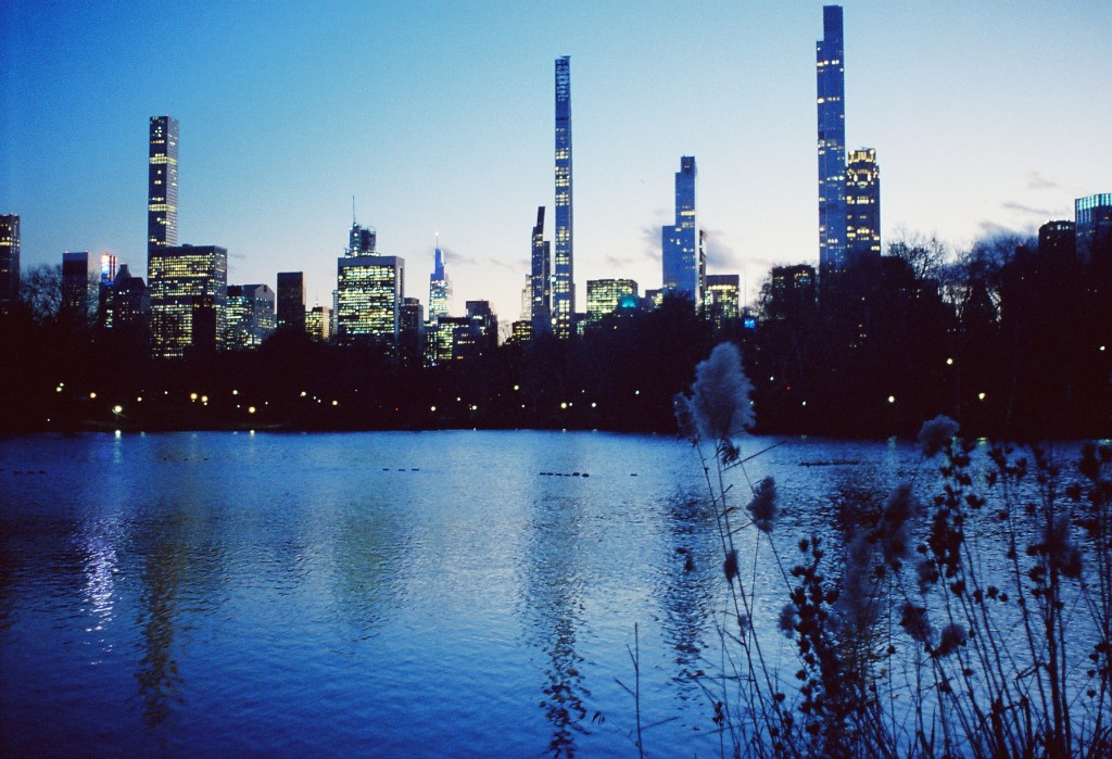 Night view of skyscrapers reflecting in the Central Park lake.